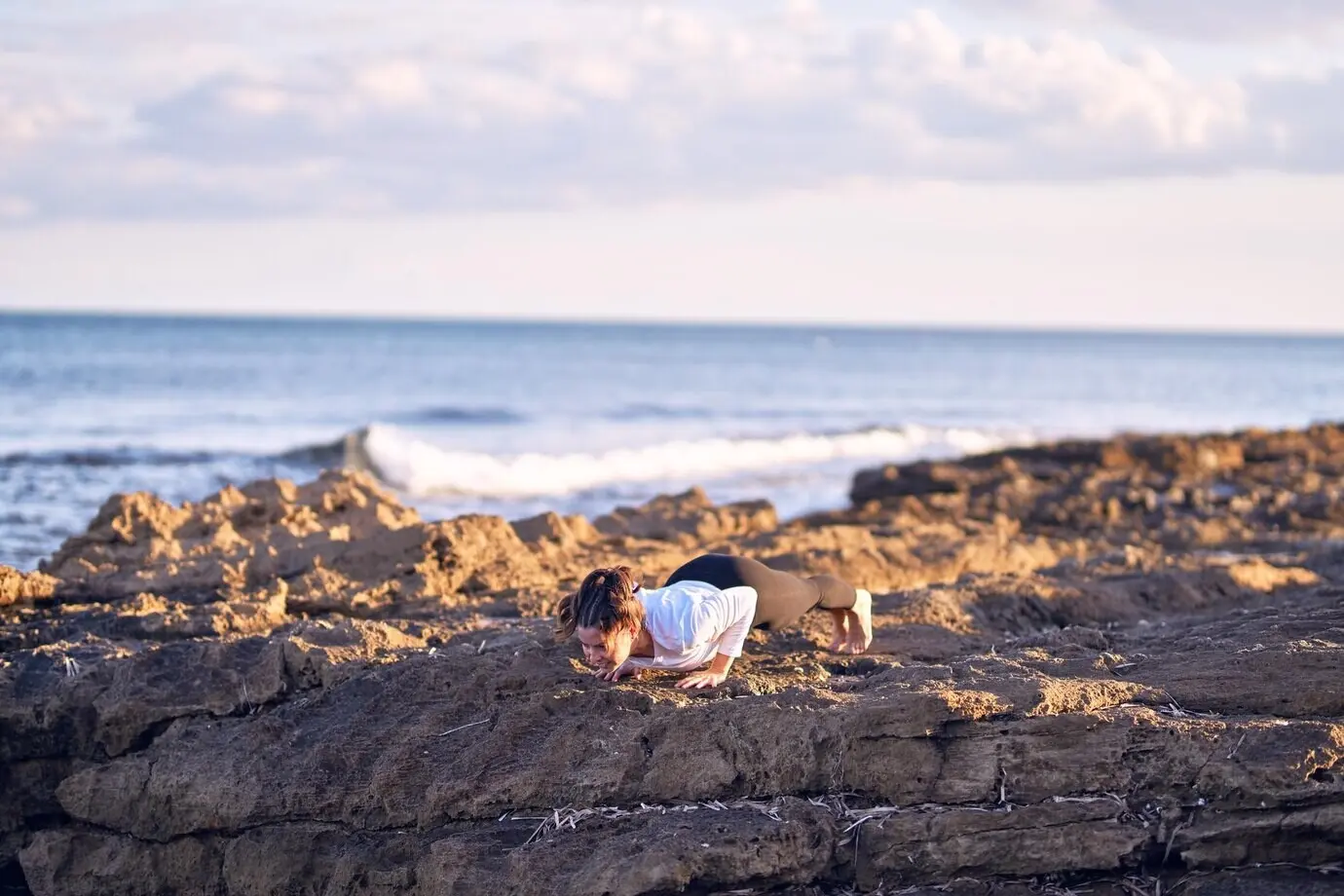 Молодая красивая спортсменка практикует йогу; тренер обучает позе «Собака мордой вверх» на пляже.